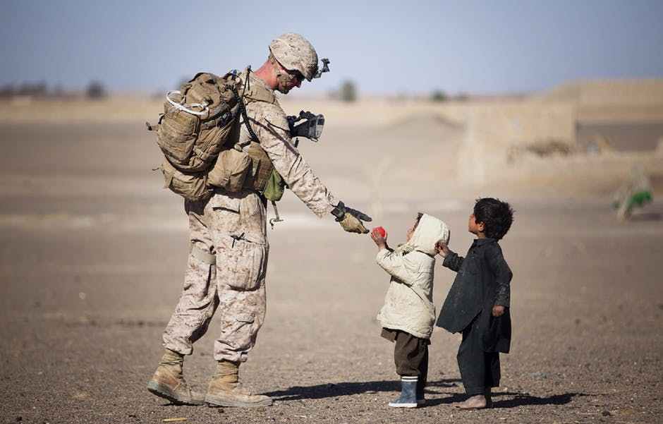 humanitarian day - soldier giving apple to kid